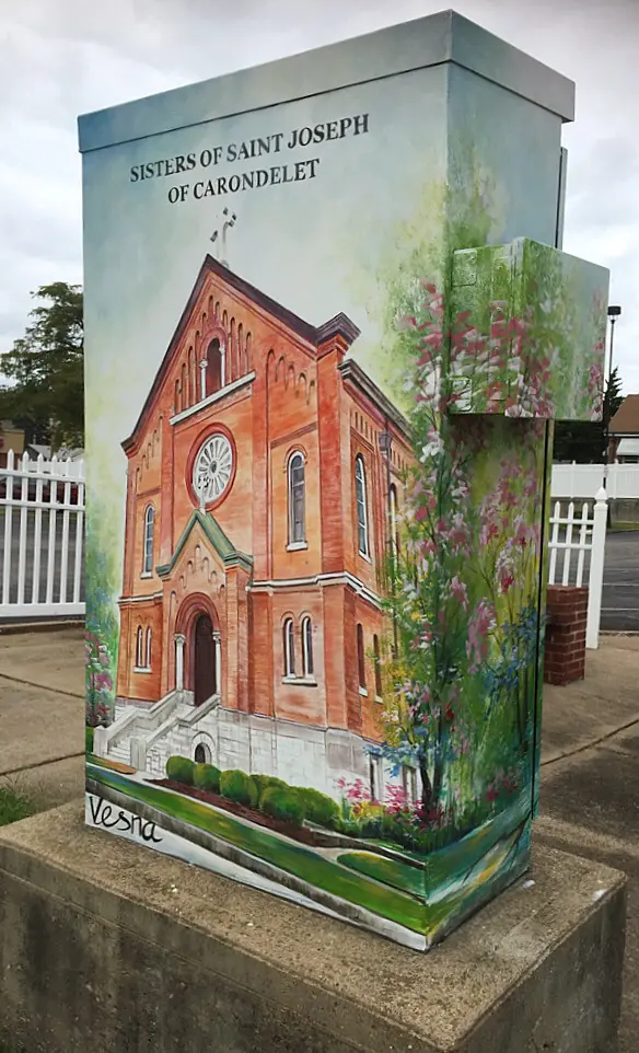A painted utility box showing a historic church
