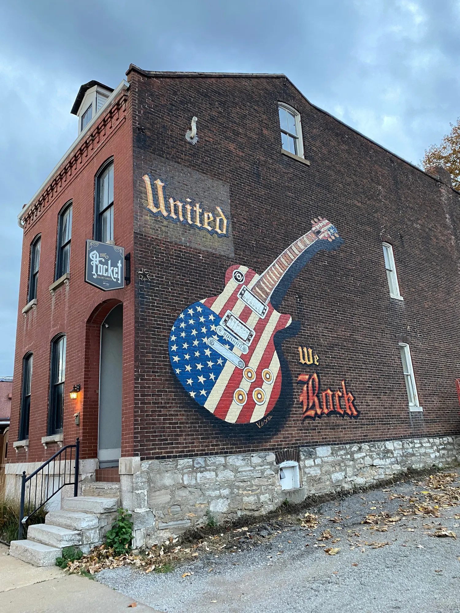 United We Rock, a mural with a guitar in the colors of the American flag on a brick building