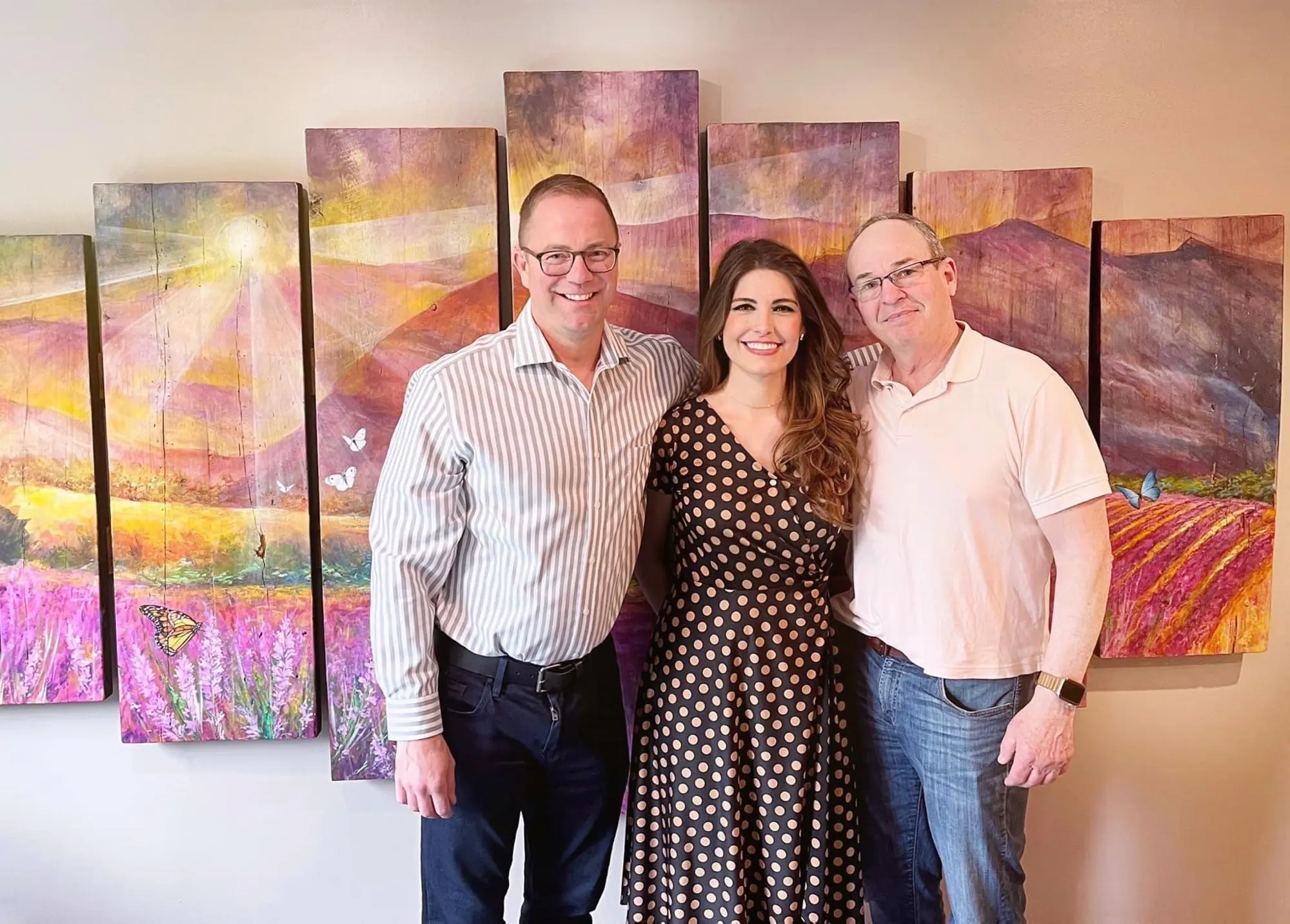 Vesna with two collectors in front of their multi-panel lavender painting